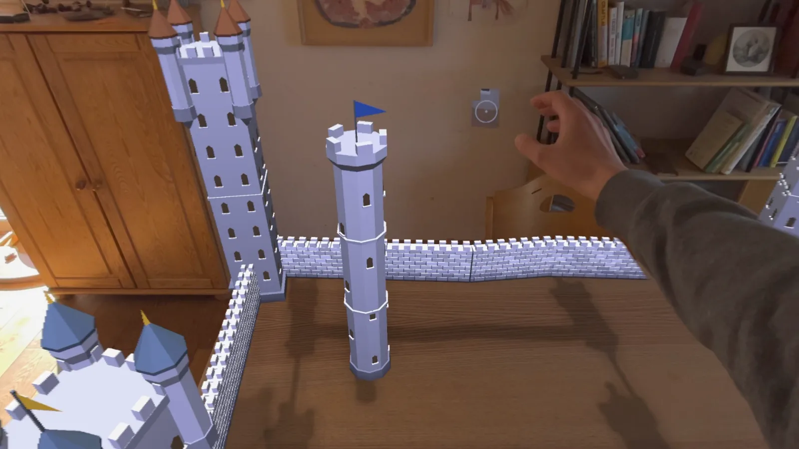 A castle wall being drawn across a table between two towers