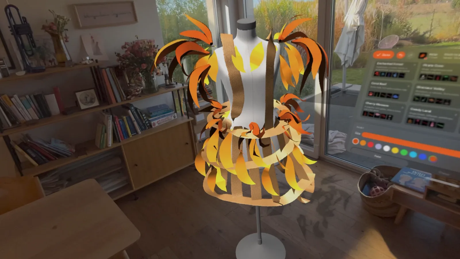 A dress form wrapped in painted strips of fire-coloured leaves in a living room